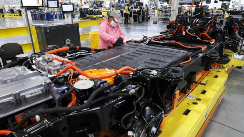 20 сентября 2022 года в центре по производству электромобилей Rouge Electric Vehicle Center в Дирборне, штат Мичиган, рабочий проверяет аккумуляторные кабели на пикапах F-150 Lightning компании Ford Motor Co. Поскольку ежегодно полмиллиона тонн аккумуляторов для электромобилей выходят из эксплуатации, их все чаще используют повторно для энергоснабжения домов и создания резервных источников питания. (Джефф Ковальски/AFP via Getty Images)