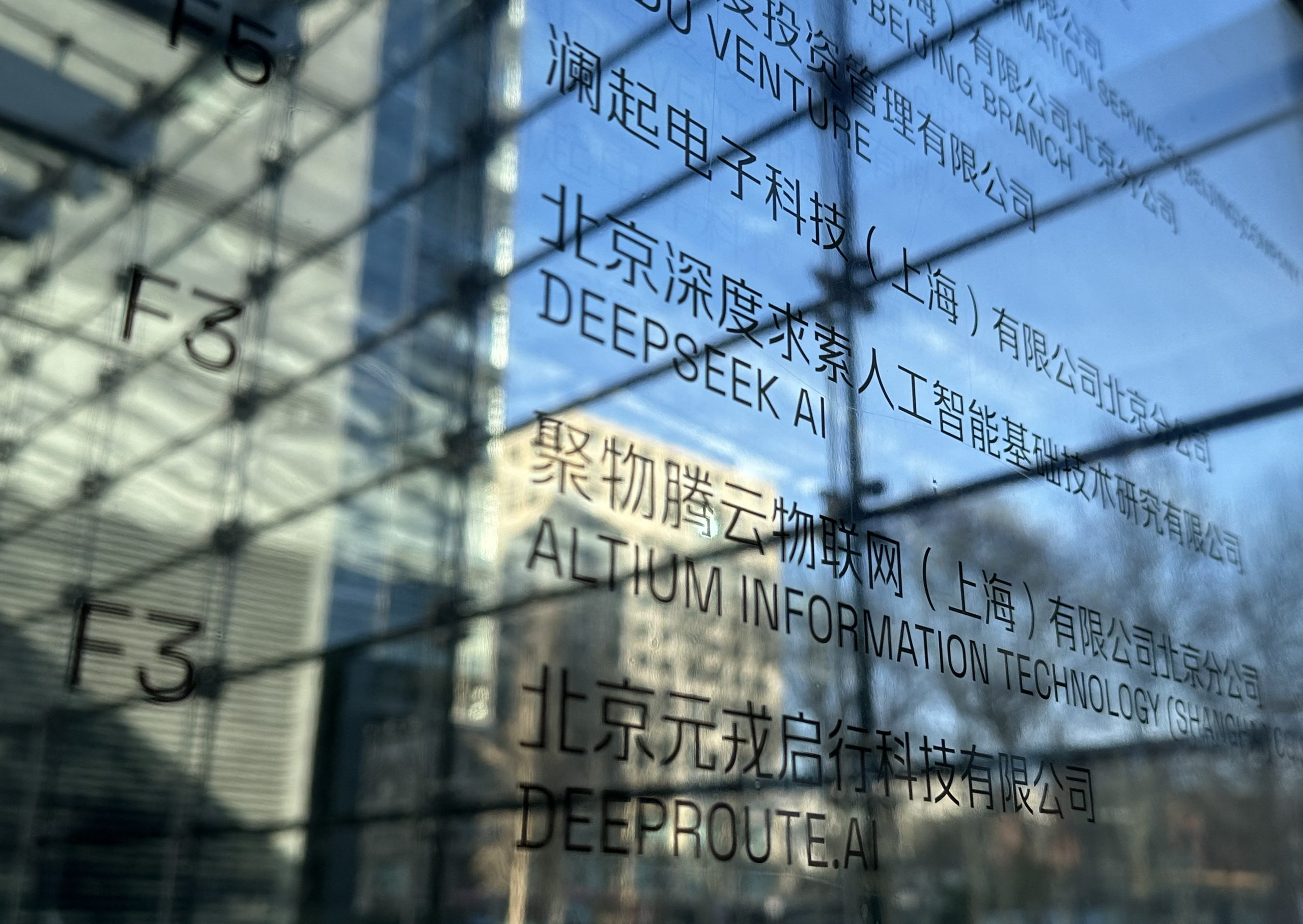 На фотографии (в центре) — вывеска офиса DeepSeek в Пекине, 28 января 2025 года. (Peter Catterall/AFP via Getty Images)