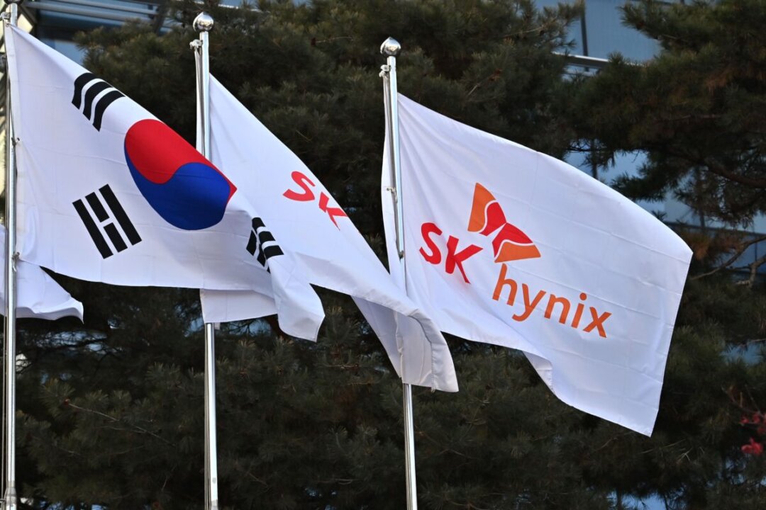 Флаг компании SK Hynix (справа) и национальный флаг Южной Кореи (слева) развеваются перед офисом компании в Бундане, Соннам, Южная Корея, 29 января 2021 года. (Jung Yeon-je/AFP via Getty Images) | Epoch Times Media