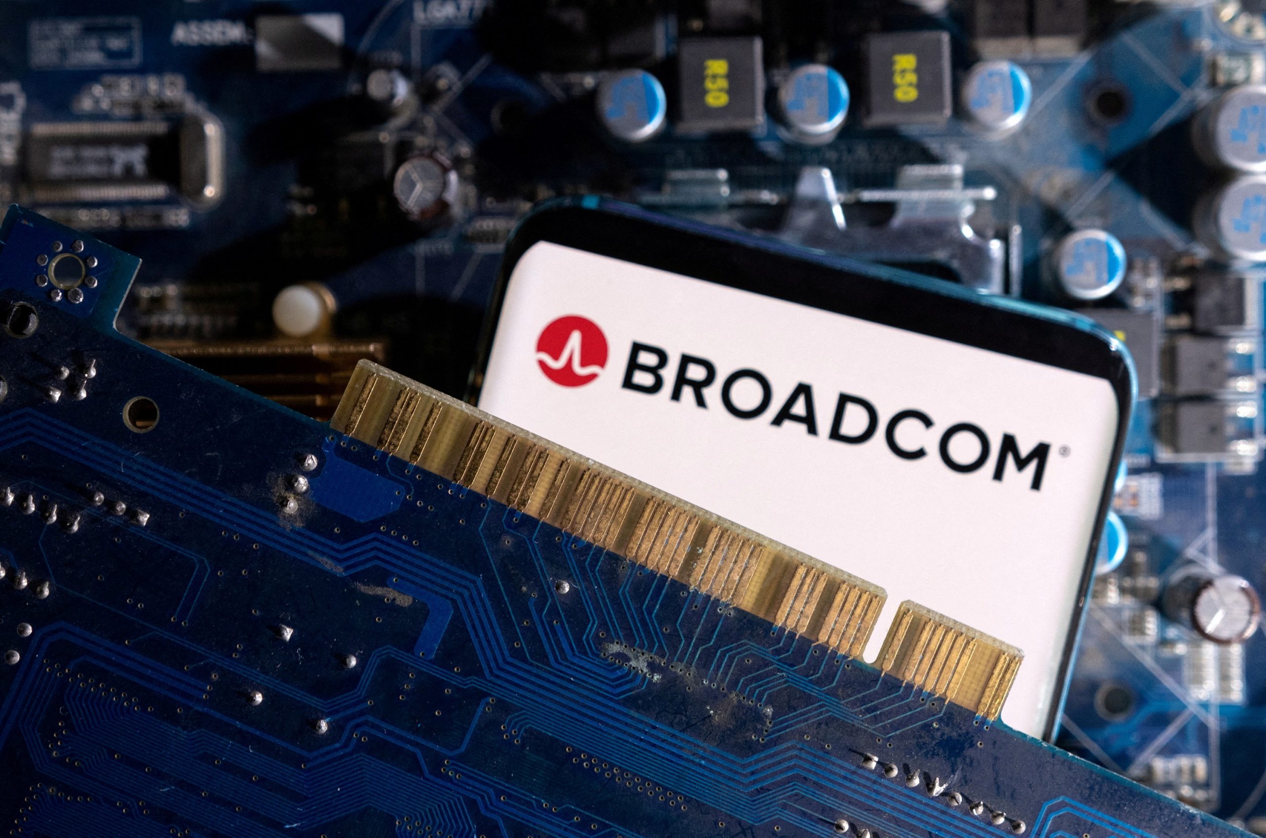 На иллюстрации, сделанной 6 марта 2023 года, смартфон с отображаемым логотипом Broadcom установлен на материнской плате компьютера. (Дадо Рувич/Иллюстрация/Reuters)
