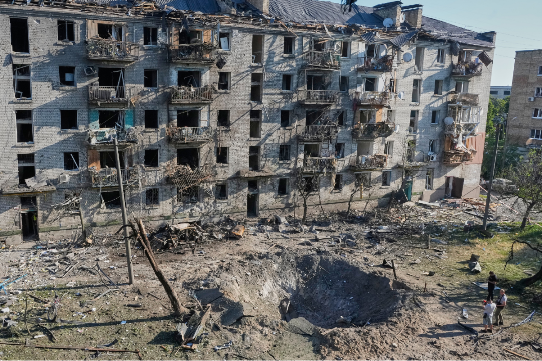 Люди осматривают место, где 2 июля 2026 года в Киеве (Украина) в жилой дом попала российская ракета. (Эфрем Лукацкий/ AP Photo) | Epoch Times Media