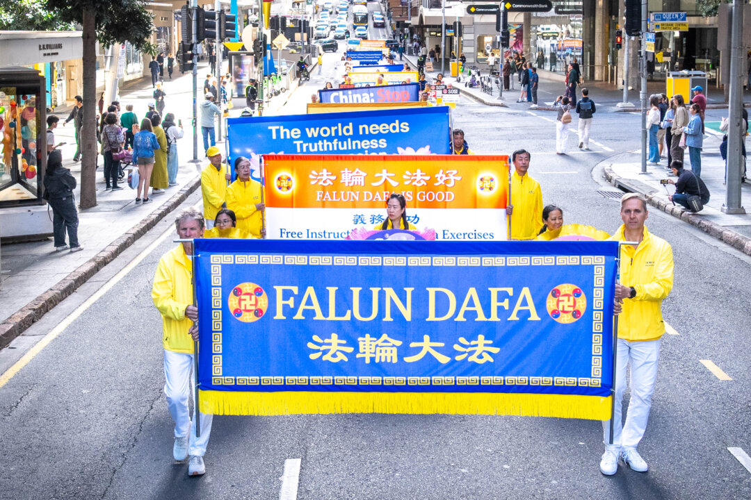 Австралийцы проходят маршем по улицам городов с транспарантами, чтобы привлечь внимание к предстоящей глобальной акции протеста 20 июля в Брисбене, штат Квинсленд, 18 июля 2026 года. С июля 1999 года миллионы последователей в Китае подвергаются незаконным арестам, пыткам и принудительному изъятию органов просто за приверженность своим духовным убеждениям. (Хонг Юань/NTD)