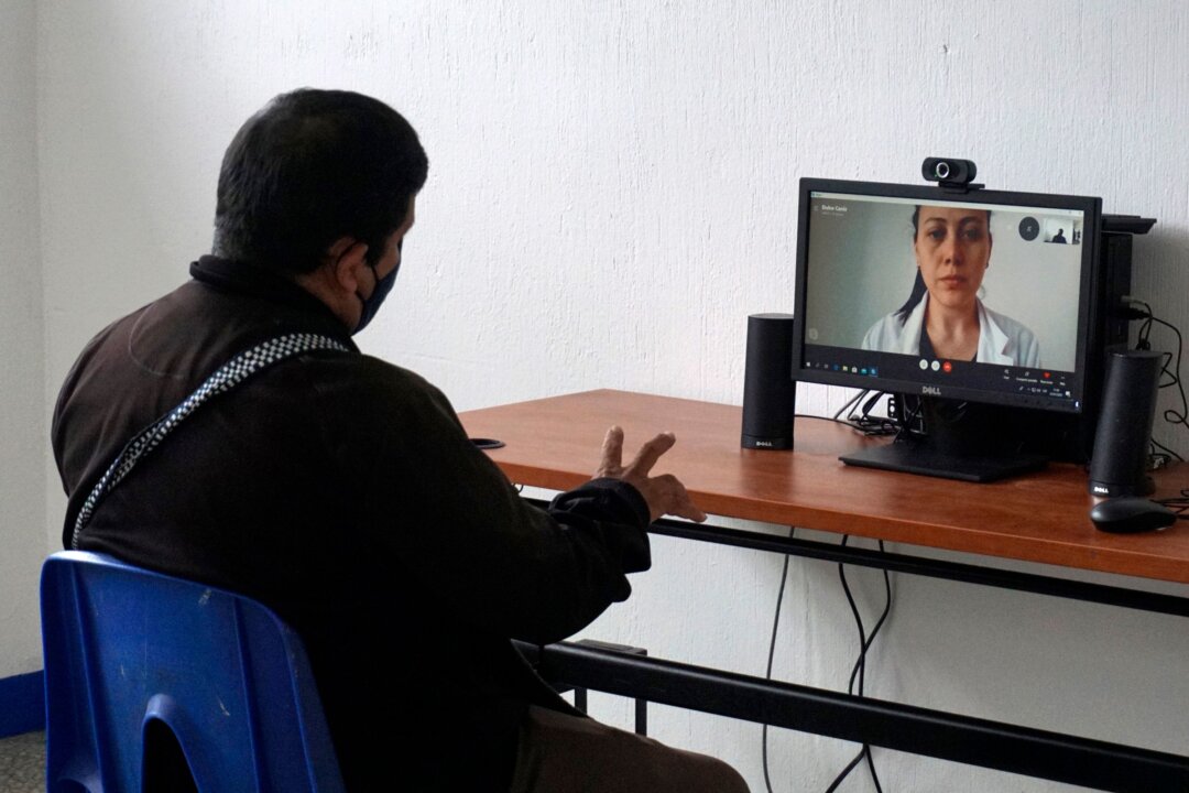 Пациент проводит виртуальную медицинскую консультацию в лагере для больных респираторными заболеваниями в городе Гватемала, 23 июля 2020 года. (Johan Ordonez/AFP via Getty Images) | Epoch Times Media