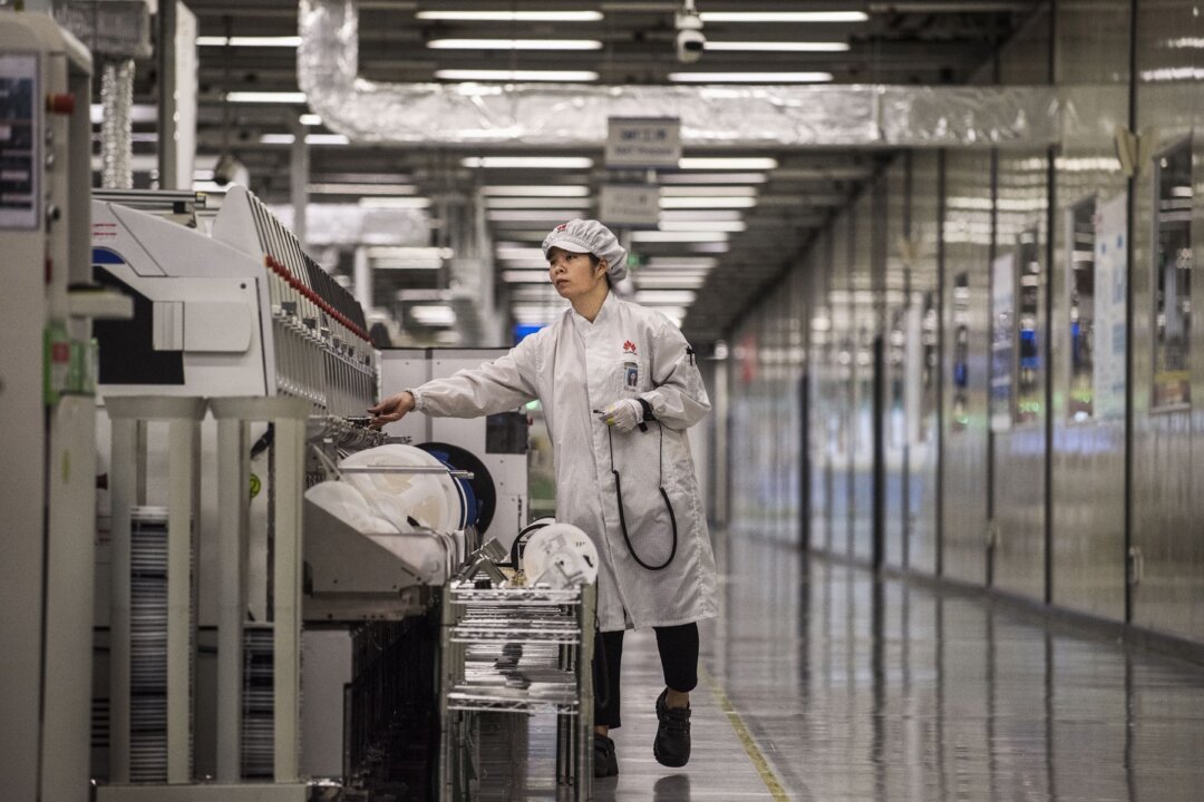 Рабочий упаковывает новые смартфоны в конце производственной линии на заводе Huawei в городе Дунгуань, провинция Гуандун, Китай, 11 апреля 2019 года. (Кевин Фрейер/Getty Images) | Epoch Times Media