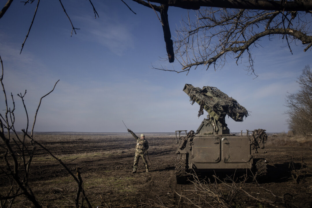Боец 72-й бригады ПВО Украины указывает в направлении замеченного над головой российского разведывательного беспилотника «Зала», готовясь к запуску зенитного ракетного комплекса «Стрела-10» недалеко от Маринки, Украина, 23 февраля 2024 года. (Крис Макграт/Getty Images) | Epoch Times Media