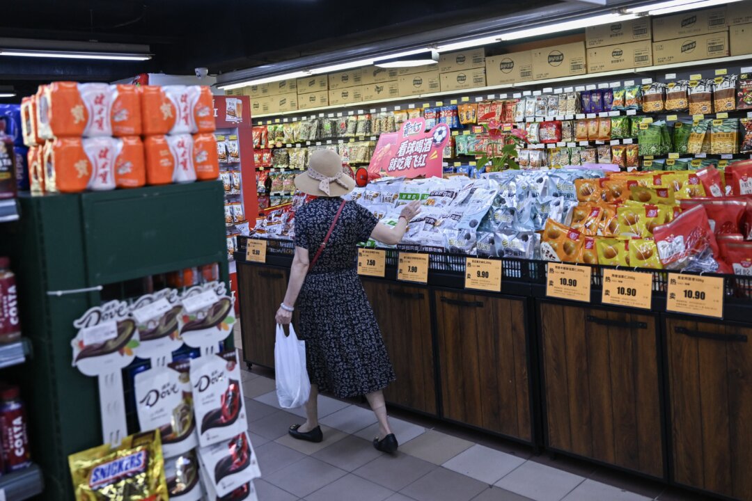 Покупатель выбирает товар в супермаркете в Пекине 17 августа 2026 года. (Pedro Pardo/AFP via Getty Images) | Epoch Times Media