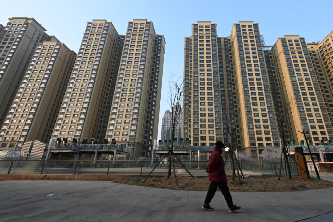 Женщина проходит мимо жилого комплекса Evergrande Palace, принадлежащего Evergrande Group, в Пекине 29 января 2024 года. (Грег Бейкер/AFP через Getty Images) | Epoch Times Media