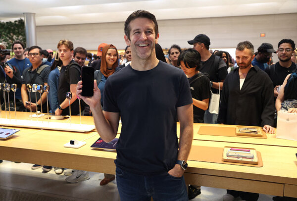Новый генеральный директор Apple, Джон Тернус, держит в руках новый iPhone 18 во время презентации iPhone в магазине Apple на Пятой авеню в Нью-Йорке 18 сентября 2026 года, посвященной дебюту iPhone 18 Pro и iPhone 18 Pro Max. (Тимоти А. Клари/AFP через Getty Images) | Epoch Times Media